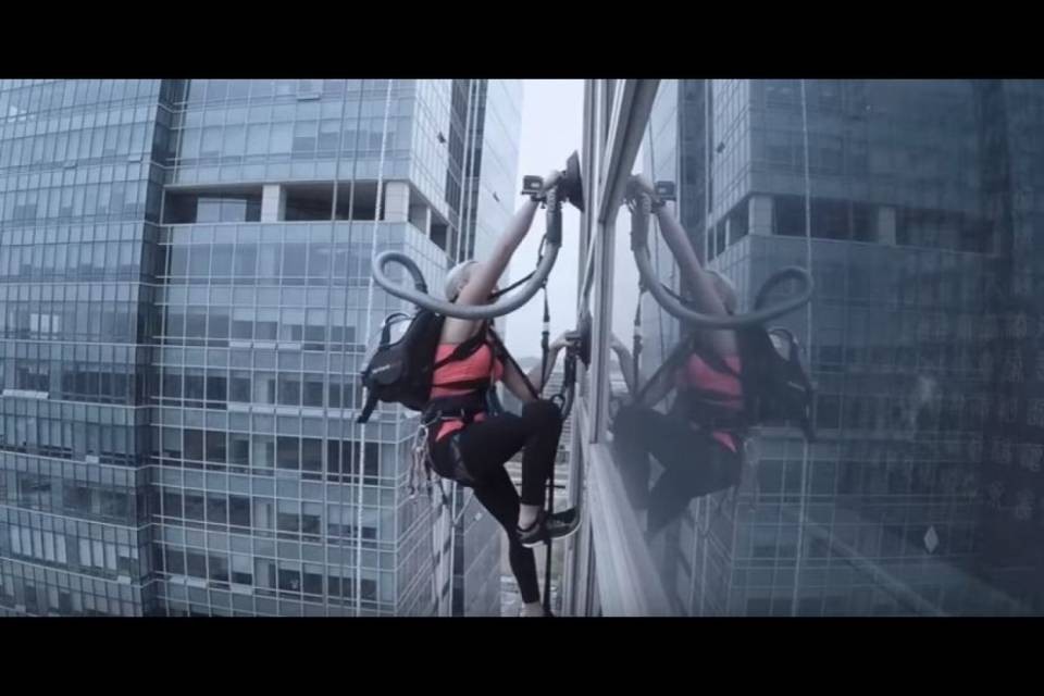 L'arrampicatrice scala un edificio con l'aspirapolvere