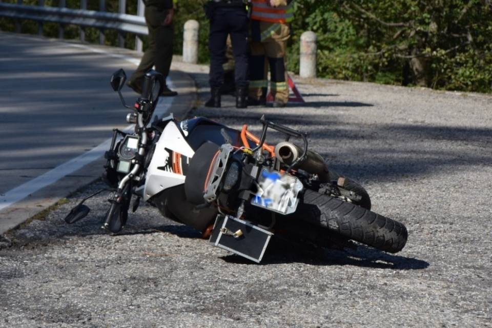 Esce da un posteggio e urta una moto in transito