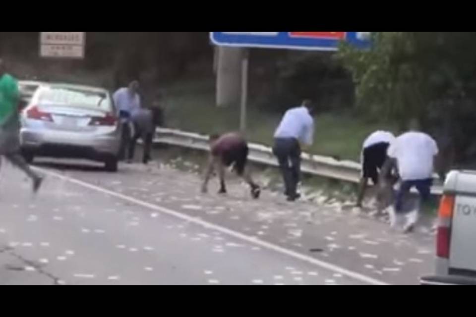 Piovono soldi in strada, automobilisti si fermano per raccoglierli